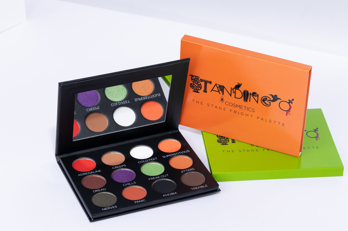 A Halloween-themed eyeshadow palettes with a mirror, shown with black, orange and slime green exterior packaging.