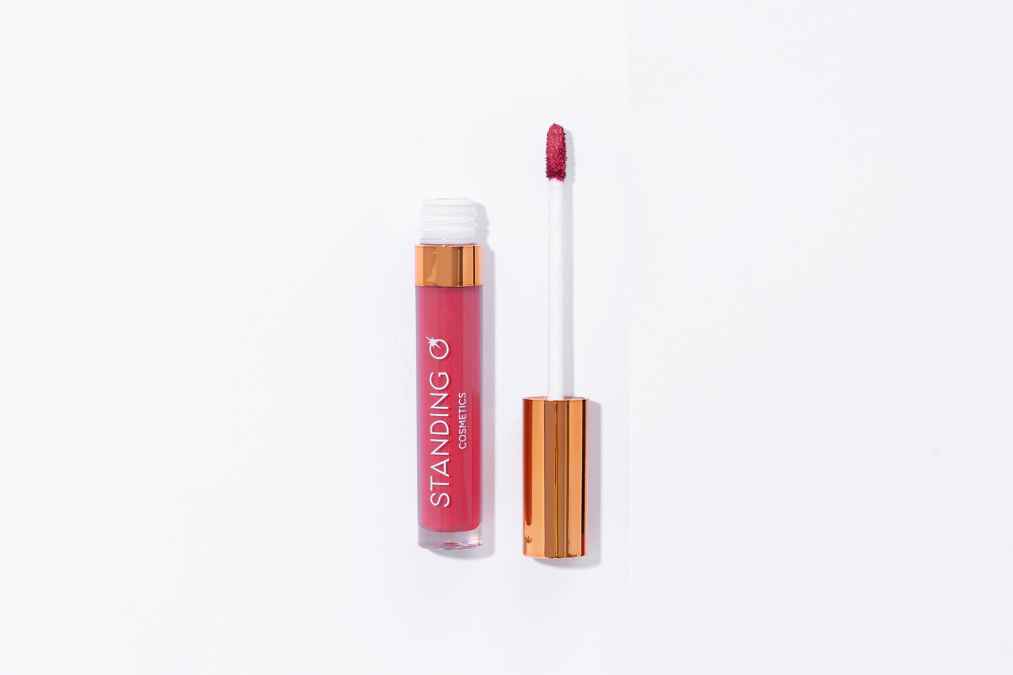 Tube of lipstick with a gold top shown open to showcase the applicator and color: feminine pink lipstick.