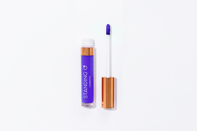 Tube of lipstick shown open to showcase the applicator and color: bright purple lipstick.