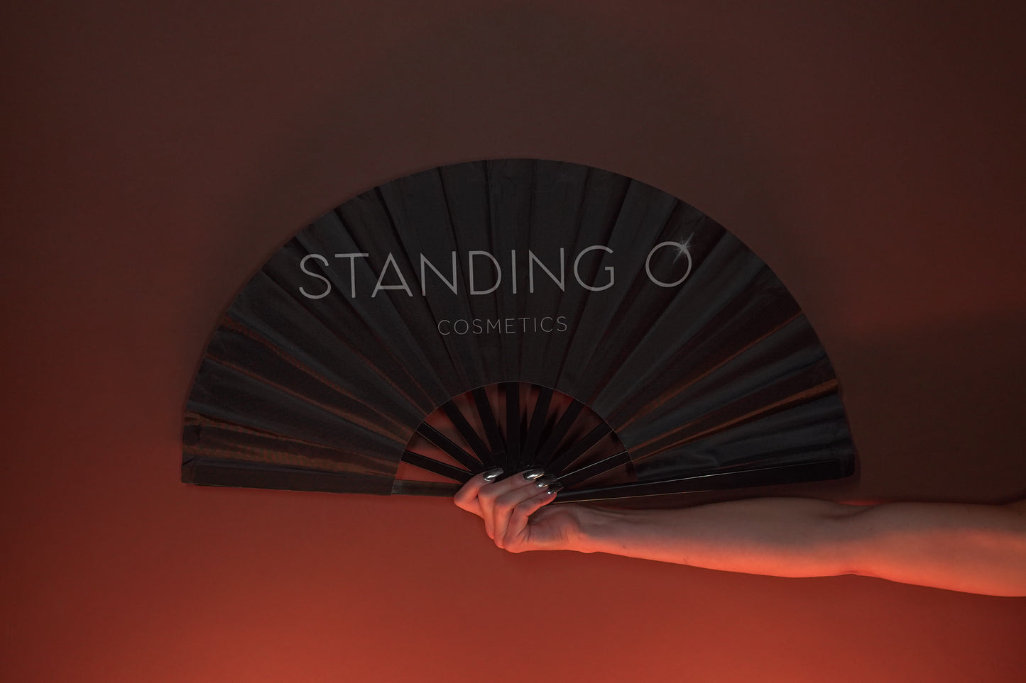 Large black hand fan with logo "Standing O Cosmetics"